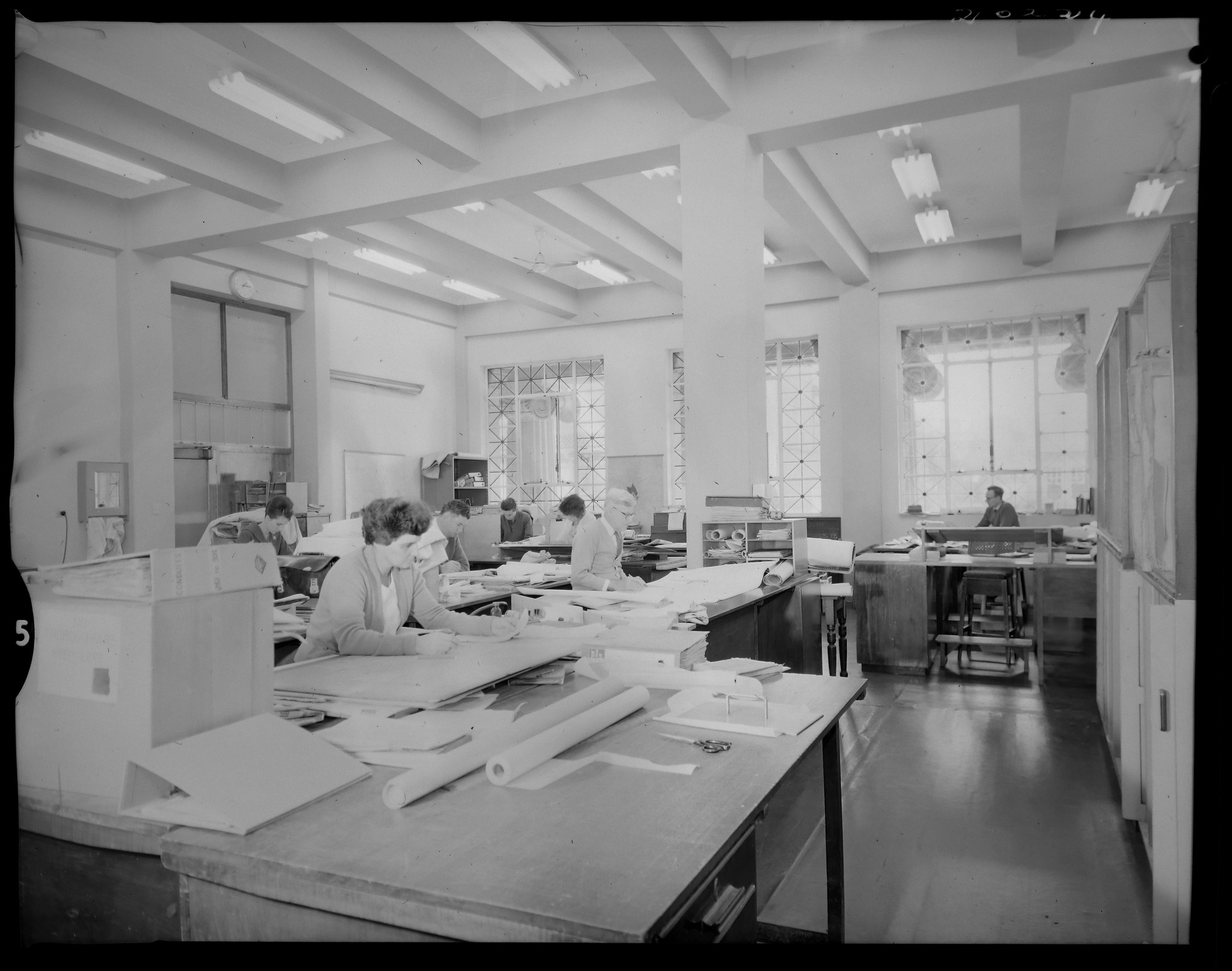 Draftswomen and draftsmen working at drafting tables in Brisbane City Hall, 1963 - showing the manual plan creation process